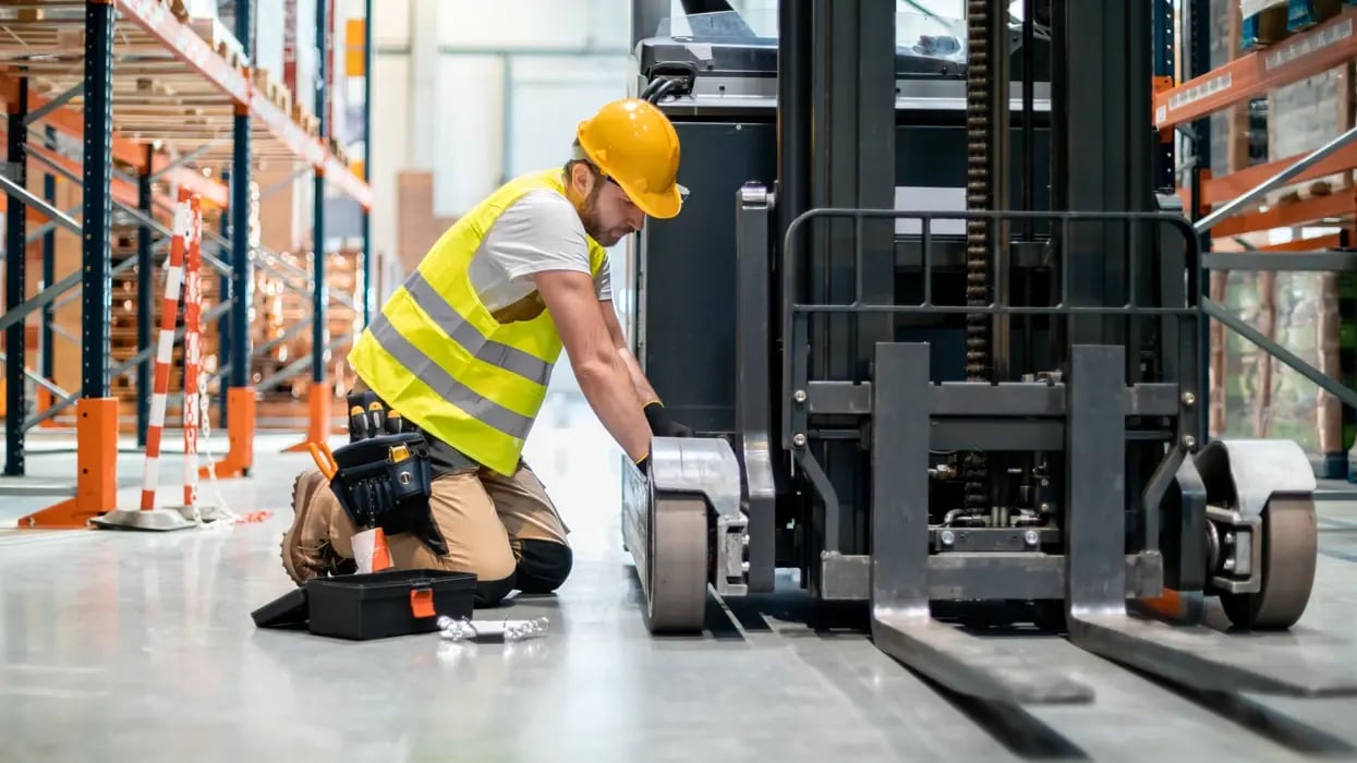 a-mechanic-fixes-a-forklift-in-a-warehouse