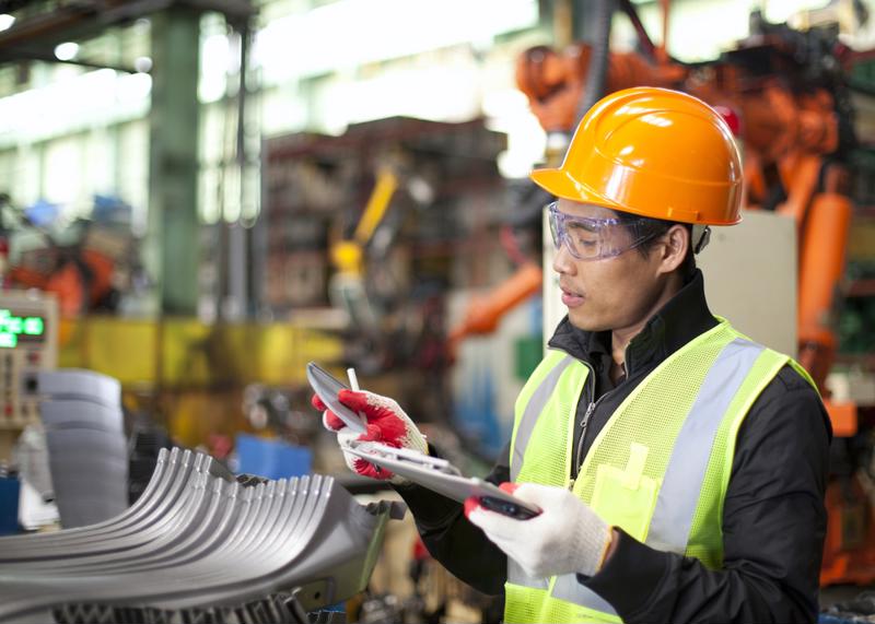 A technician reviews information on a clip board.