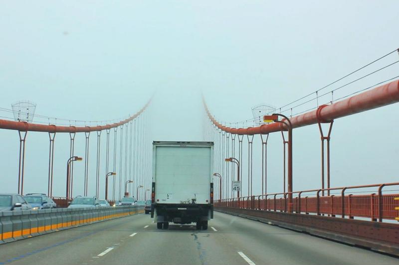 A semi truck drives over the Golden Gate Bridge.