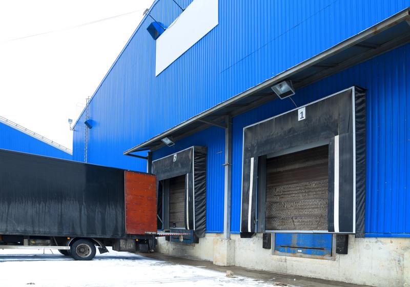 A truck backs up to a loading dock with dock seals.