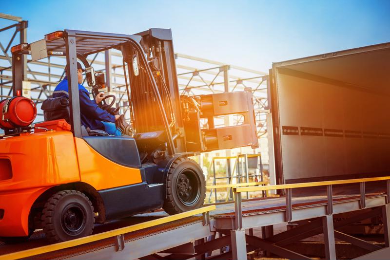 A forklift hauls inventory into a trailer.