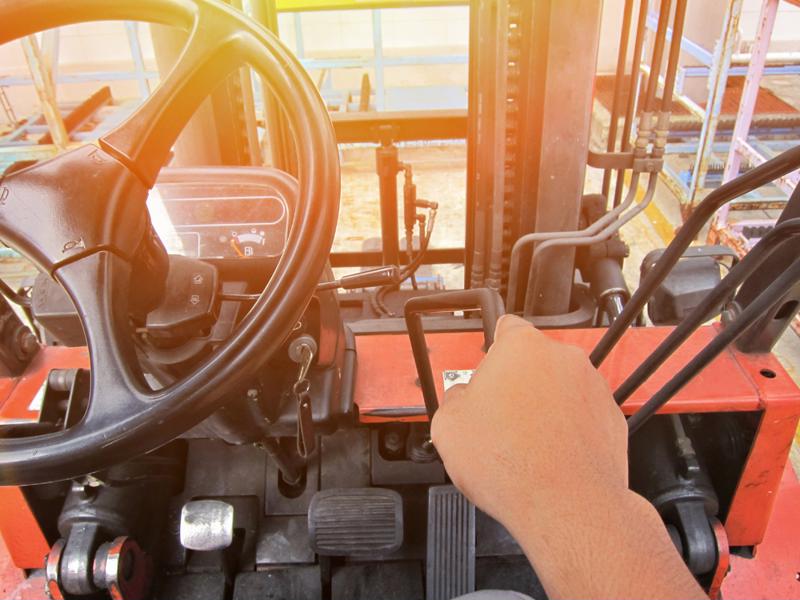 An employee drives a forklift through a facility.